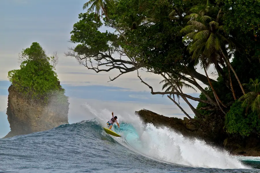 A surfer riding past the sea stack at Pinnacles
